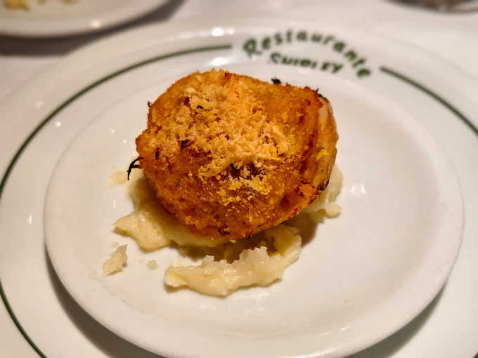 Bolinho de bacalhau servido sobre purê